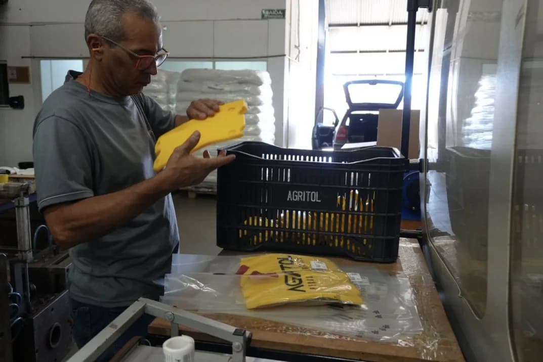 Colaborador da Agritol inspecionando uma peça usinada na bancada.